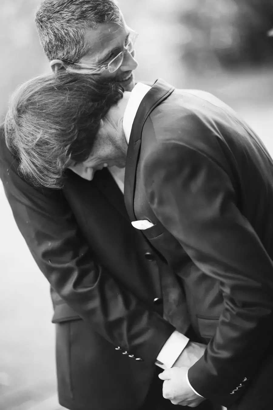 Emotionale Schwarz-Weiß-Hochzeitsfotografie: Nahaufnahme eines Bräutigampaares bei einer innigen Umarmung. Authentischer Fotojournalismus und ungestellte Momente in Wien. Zeitloser Look und echte Gefühle eingefangen von Still and Motion Pictures.
