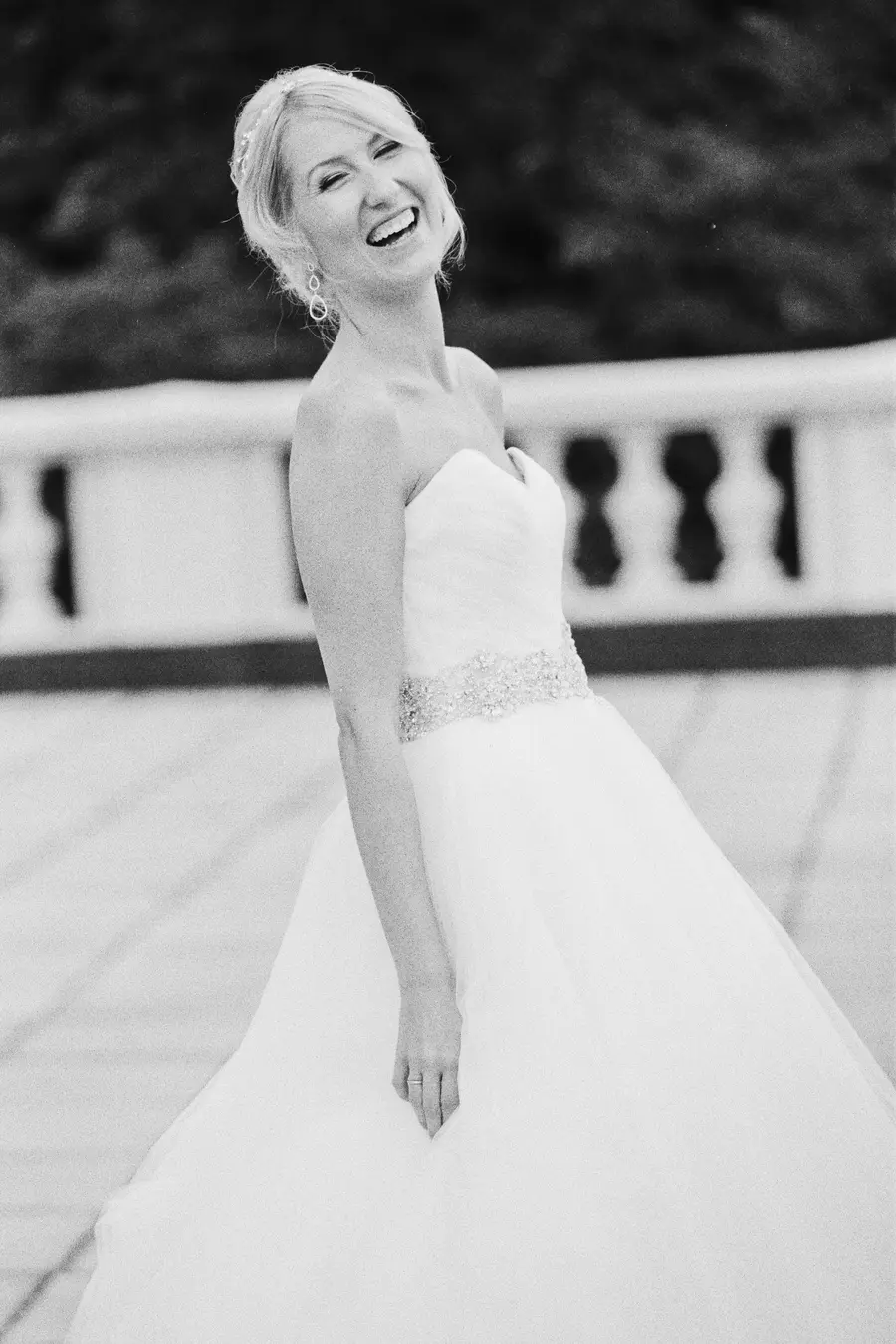 A smiling bride in a natural pose. Soul of grainy B&W analog film photgraphy