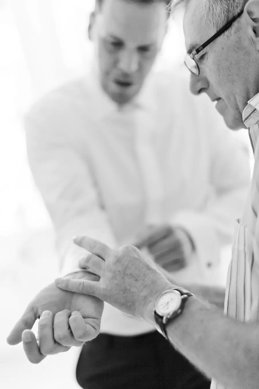 Father helps groom to wear wedding dress
