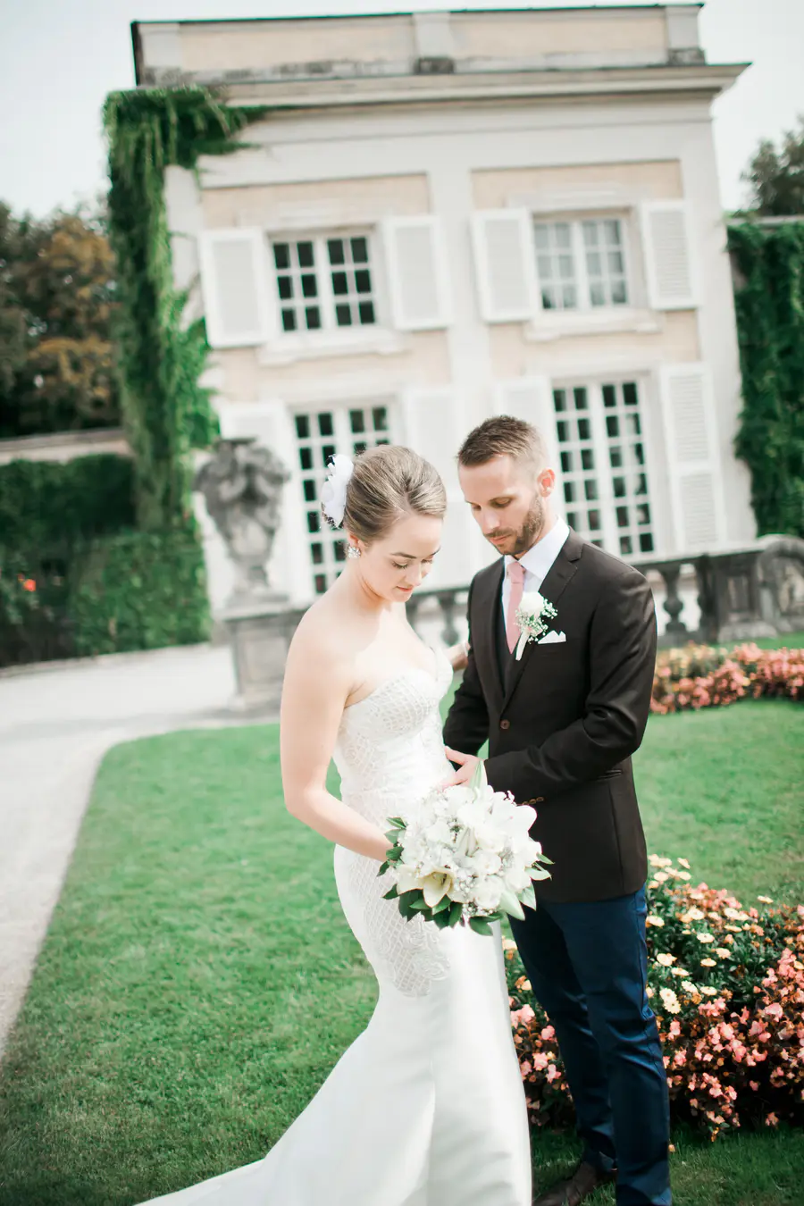 A natural shot of a bride and groom walking through the historic Mirabell Gardens, capturing a quiet, authentic moment in Salzburg.