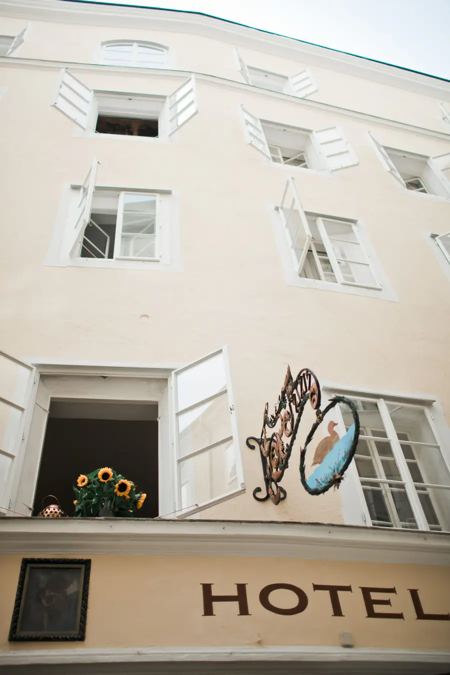 A beautiful exterior shot of the boutique Hotel Goldgasse in the heart of Salzburg’s Old Town, capturing the charm of the narrow historic street.