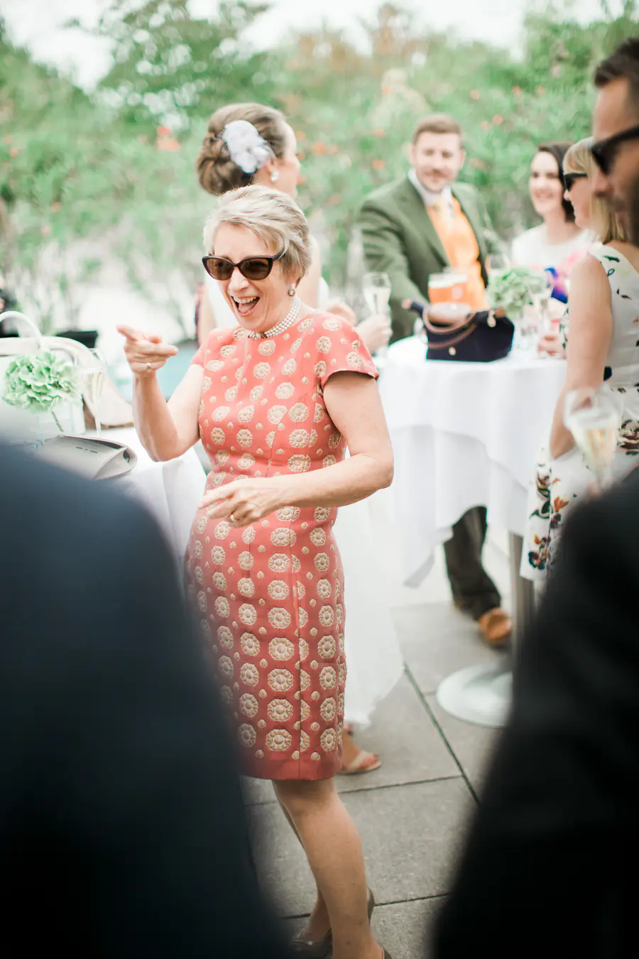  candid photojournalistic frame of wedding guests laughing and sharing stories, capturing the genuine joy of the celebration.