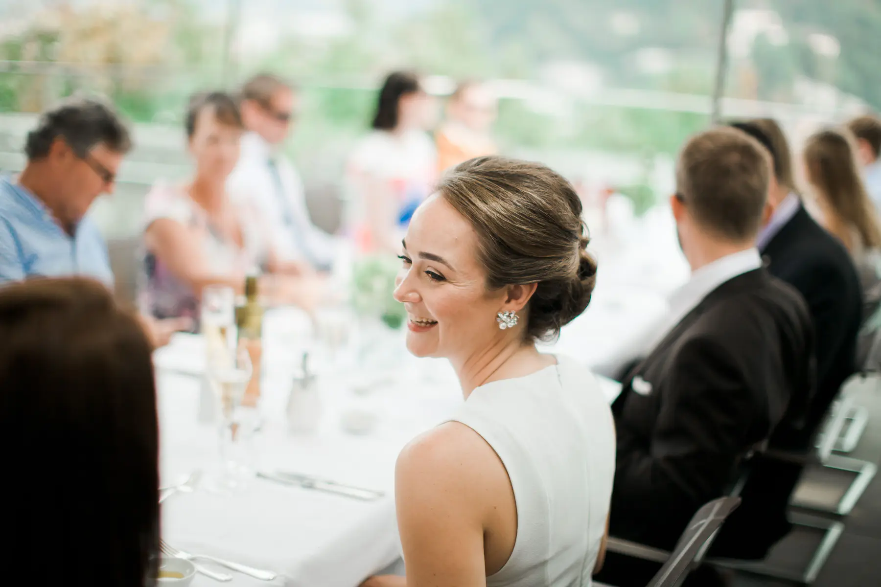 A natural and relaxed shot of the bride sitting at the wedding table, looking radiant and joyful during the celebration at m32 restaurant.