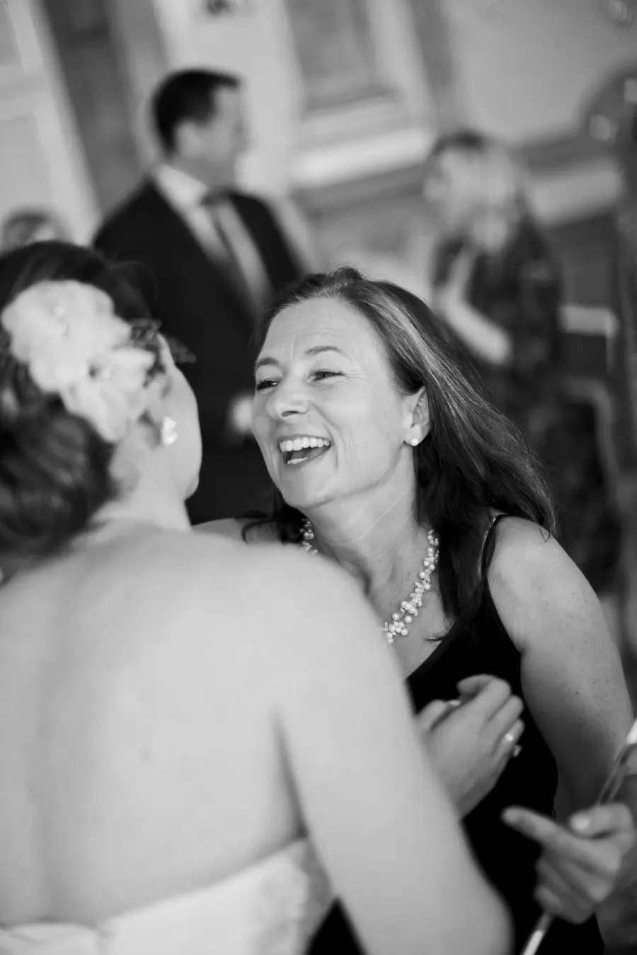 Joyful conversation between two women at a wedding celebration.Mirabell Palace wedding photojournalism