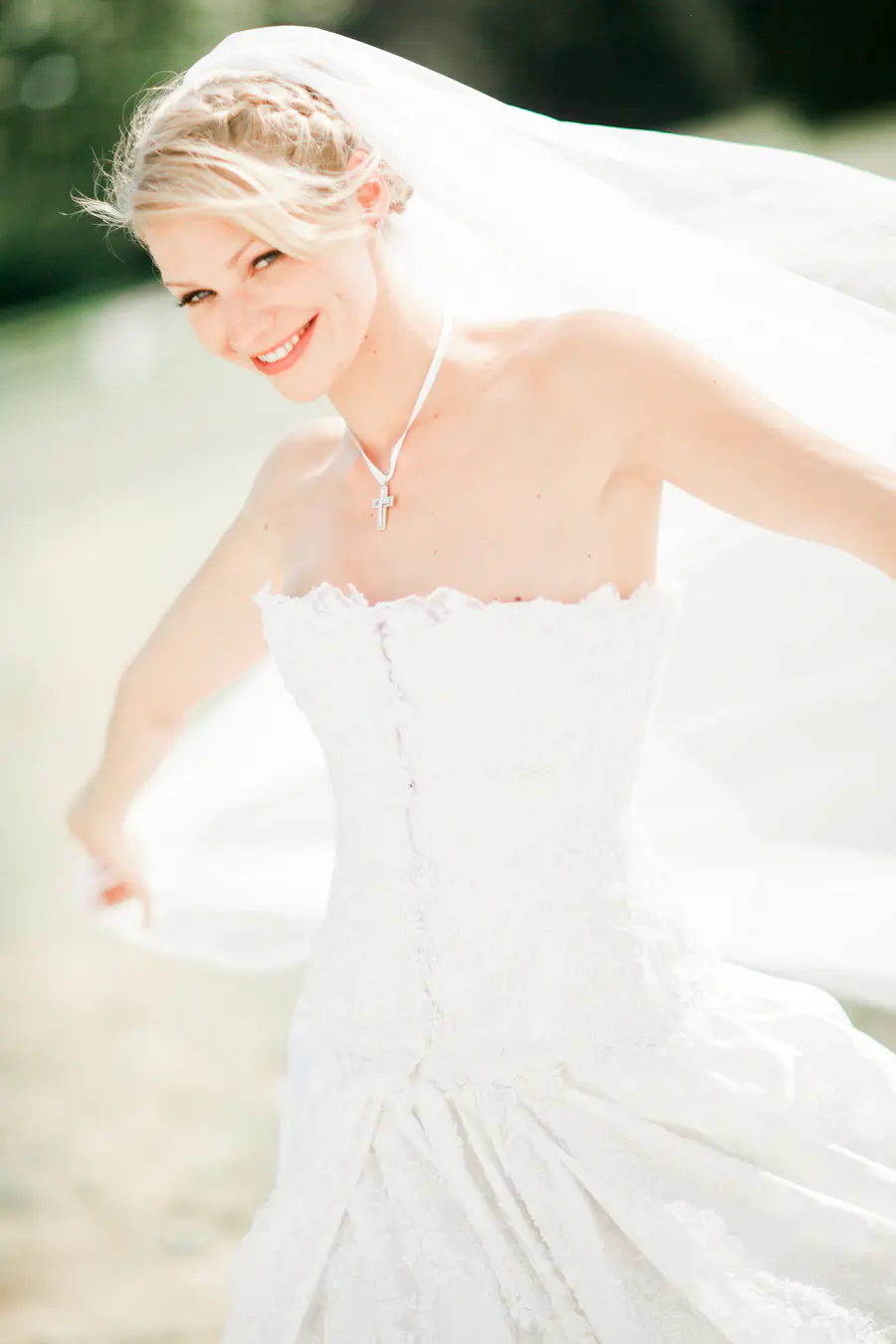 Joyful bride in a lace wedding dress on the sun.