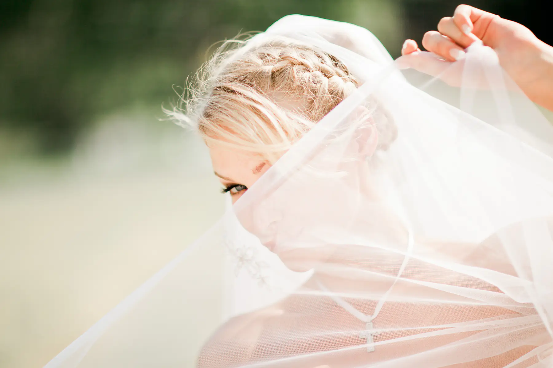 Joyful bride in hiding behind veil.