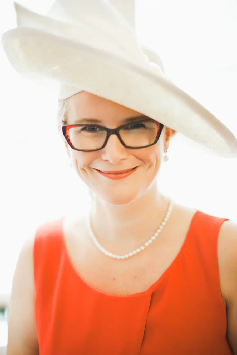 Elegant woman in hat smiling to camera