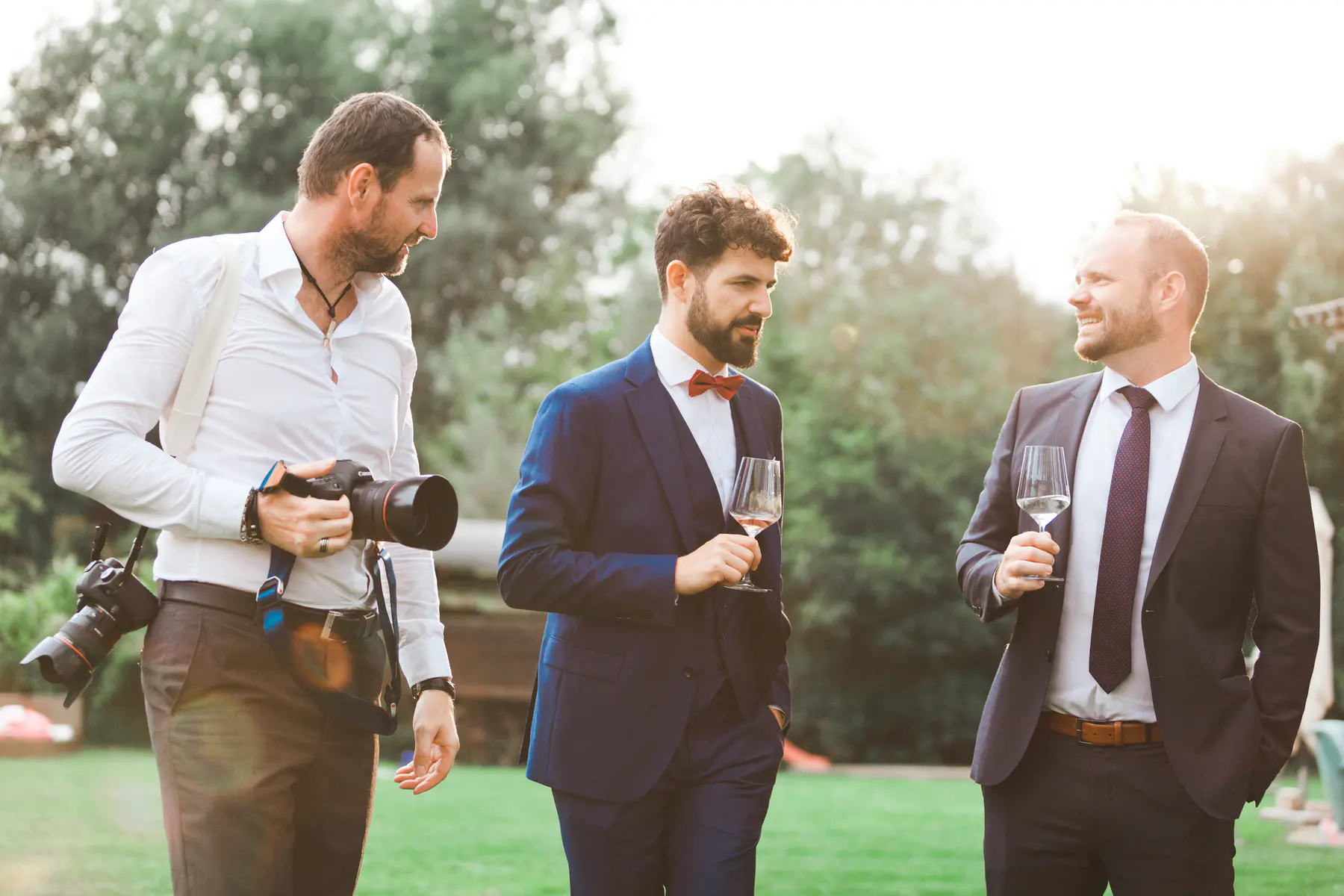 Authentic wedding photographer sharing a candid chat with the groom during a wedding session.