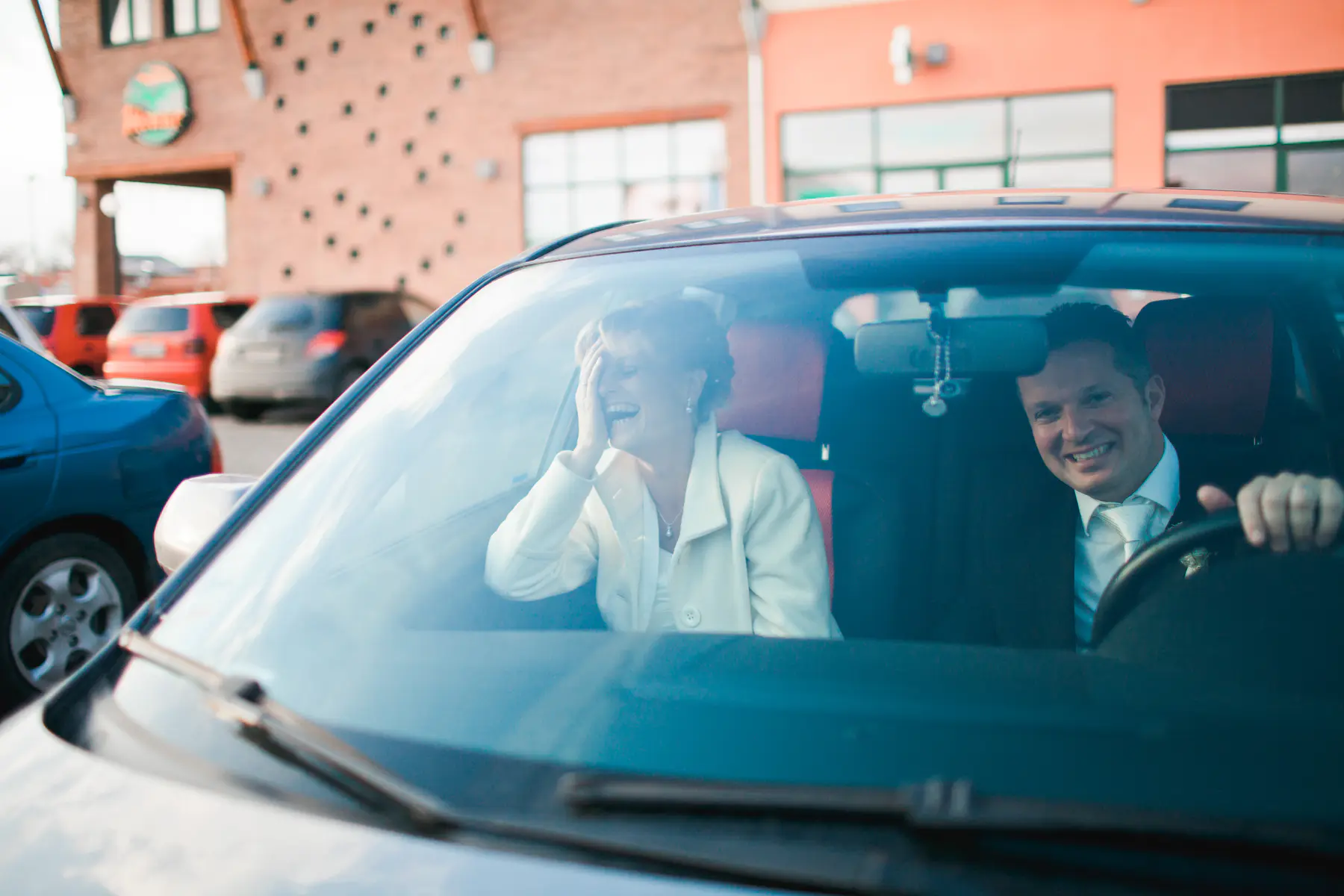 Authentic wedding photojournalism Vienna – Bride and groom sharing an emotional candid moment in a luxury car, natural light photography by Stillandmotion duo.