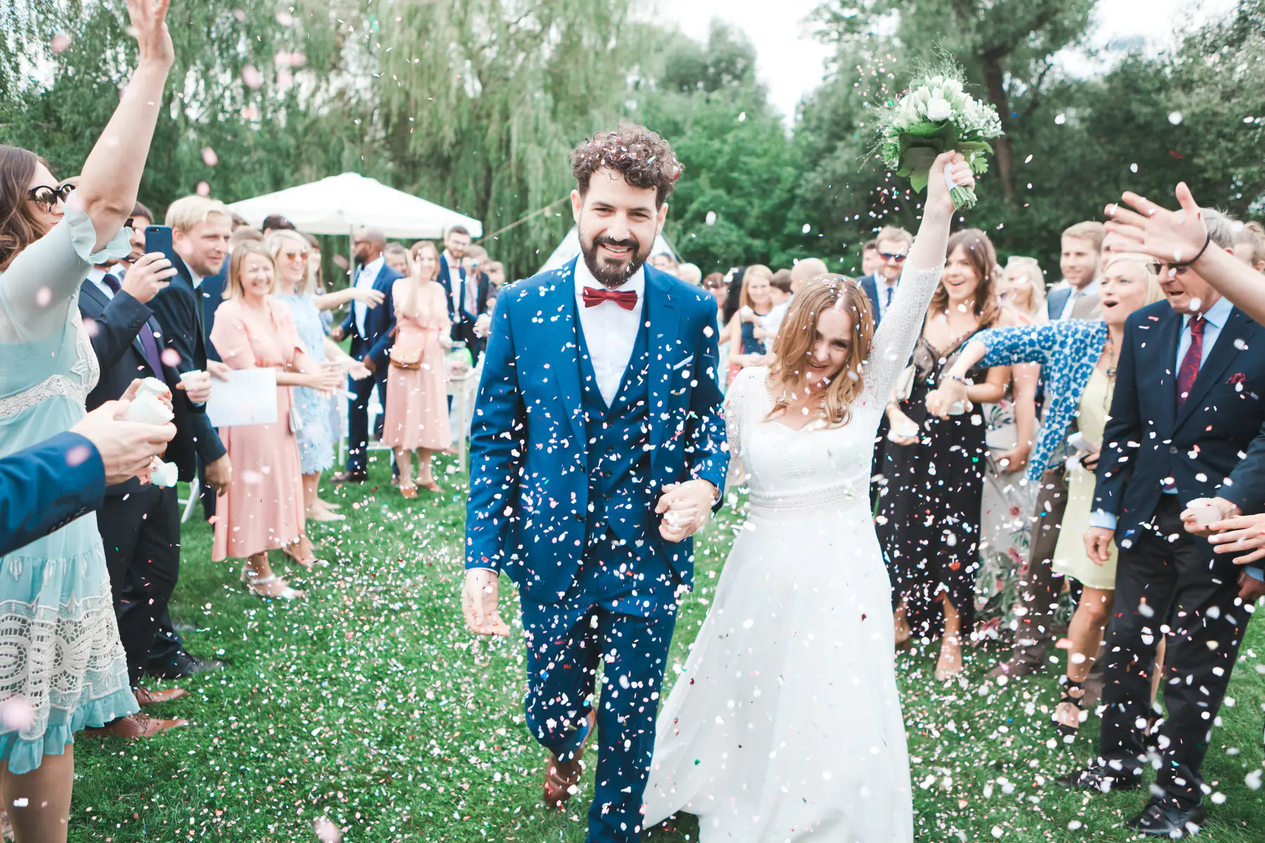 Documentary wedding cinematography Salzburg – Couple walking through raining confetti in pastel wedding palette, unscripted storytelling by Stillandmotion.