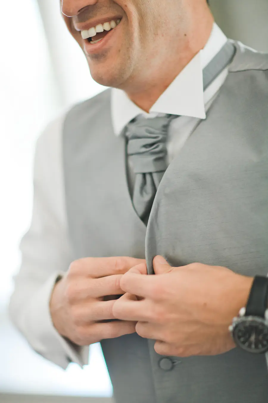 Subtle candid moment of a groom getting ready, natural wedding photography duo.