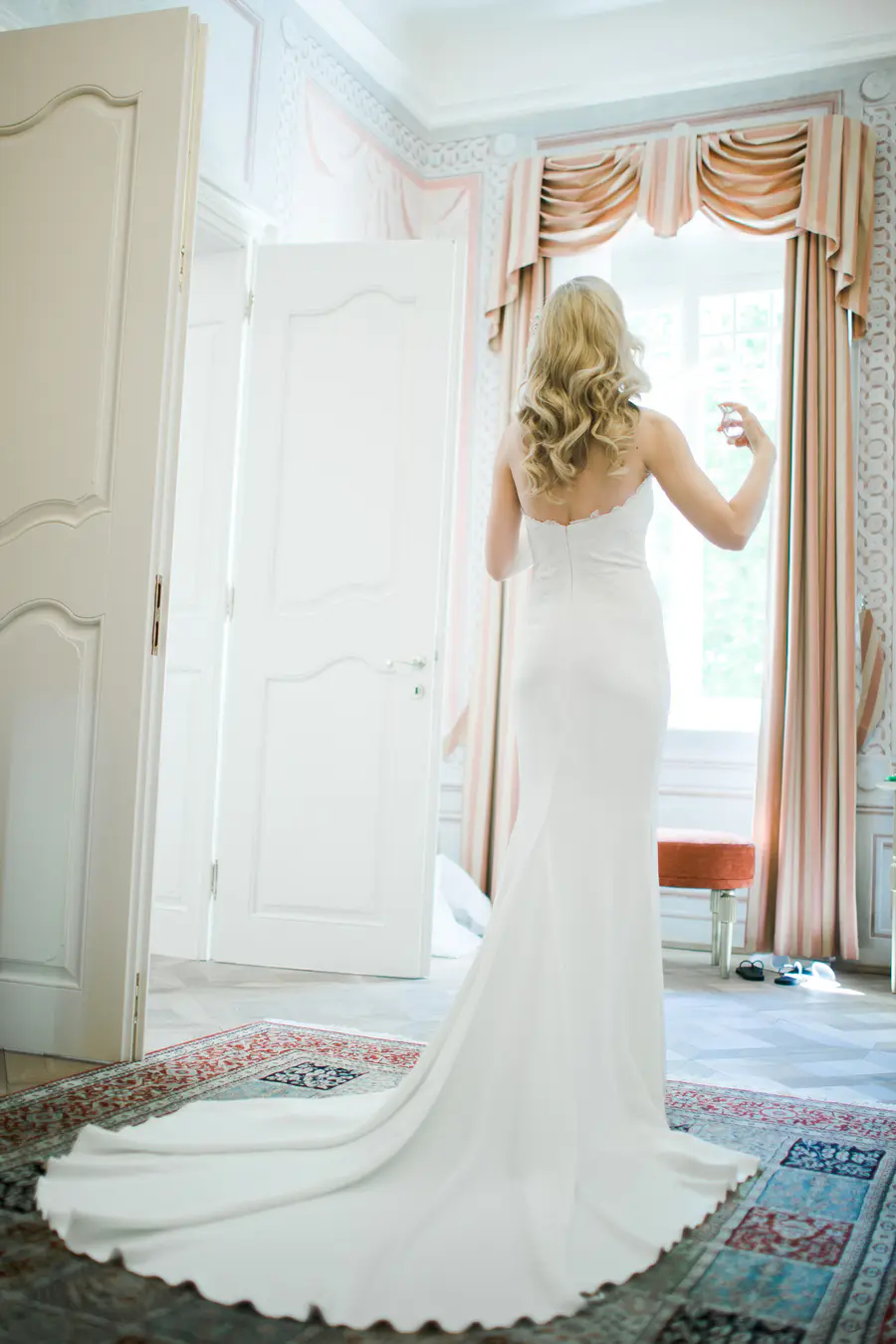 Fine art bridal portrait in the elegant interiors of Kastiel Tomasov, soft natural lighting. Bride Putting on Perfume