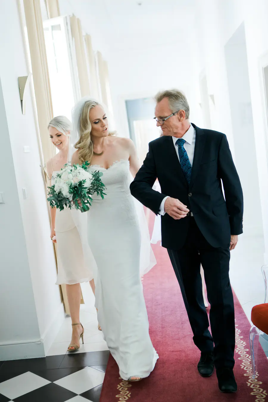 Emotional moment of a bride walking with her father towards the ceremony in the sunny park of Kastiel Tomasov.