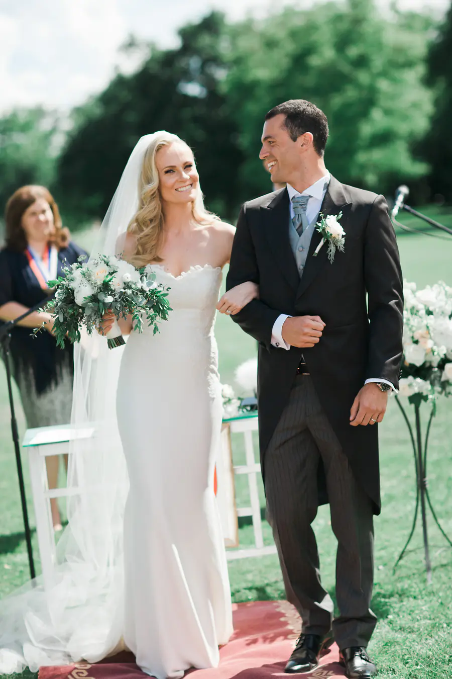 Bride and groom exchanging looks during a sunny garden wedding at Kastiel Tomasov, captured by a photography duo.
