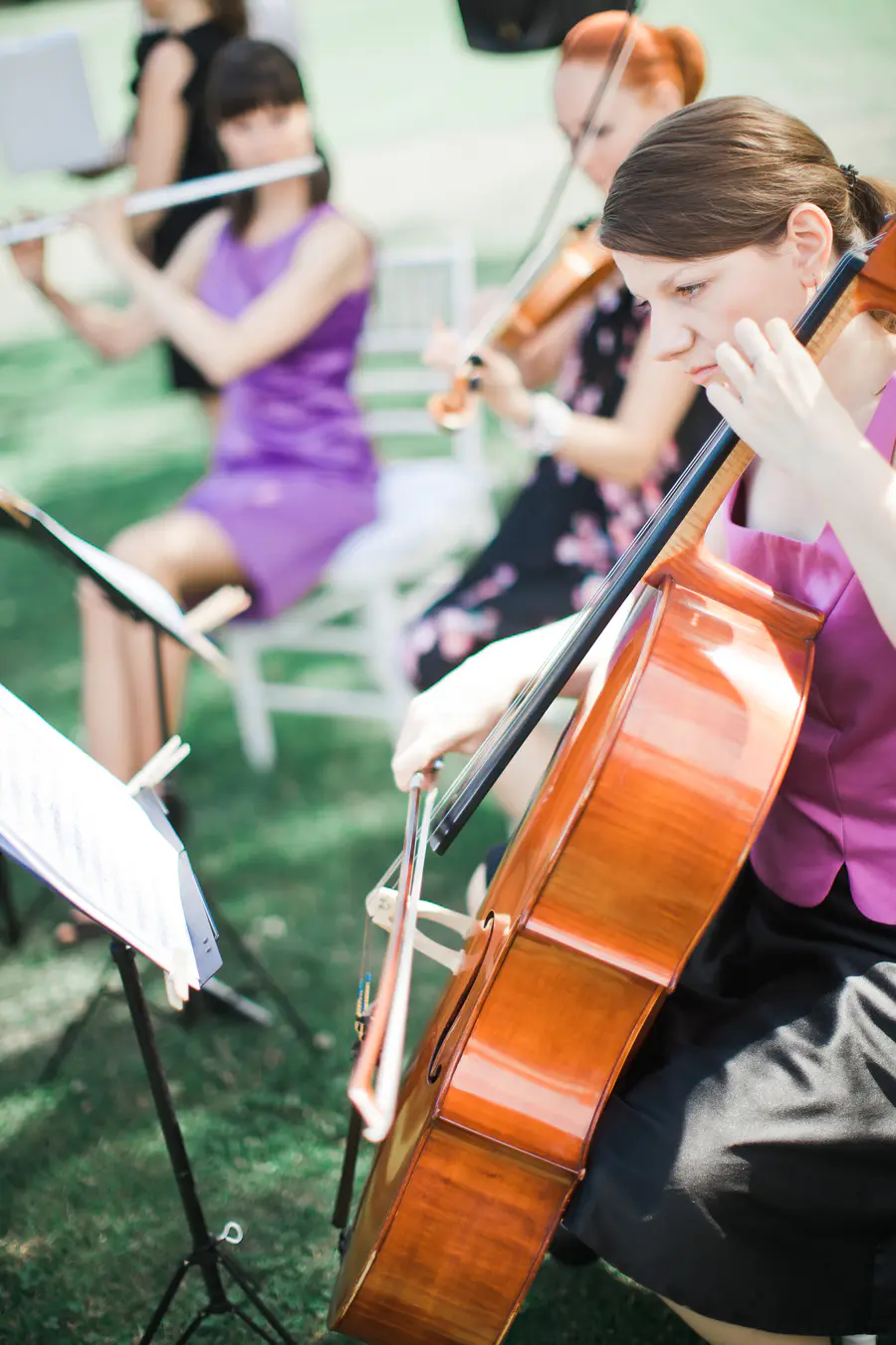 Live musicians playing during a romantic outdoor wedding ceremony in a historical manor house park.