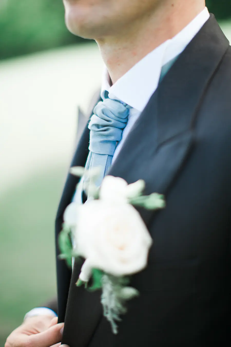Close-up of a floral boutonniere pinned to a groom's suit jacket, wedding details Slovakia.