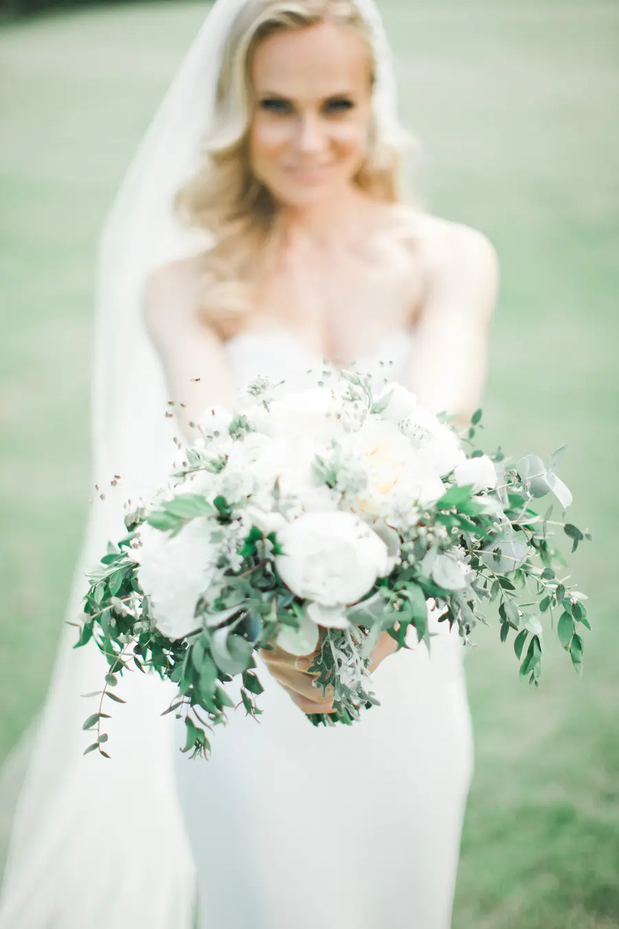  Elegant bride posing with a lush floral bouquet in the parkof historic Art Hotel Kastiel Tomasov.