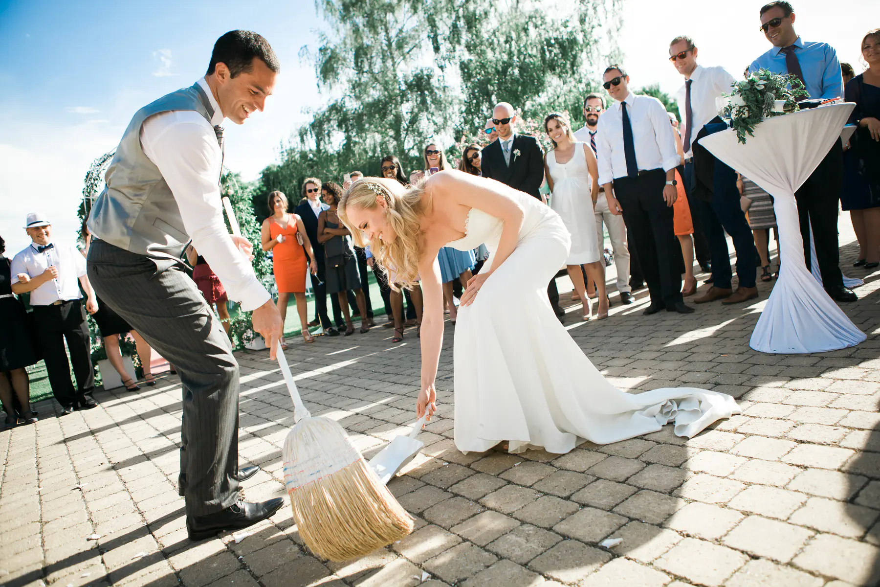 Newlyweds sweeping broken plates, a traditional Slovak wedding custom at Kastiel Tomasov.