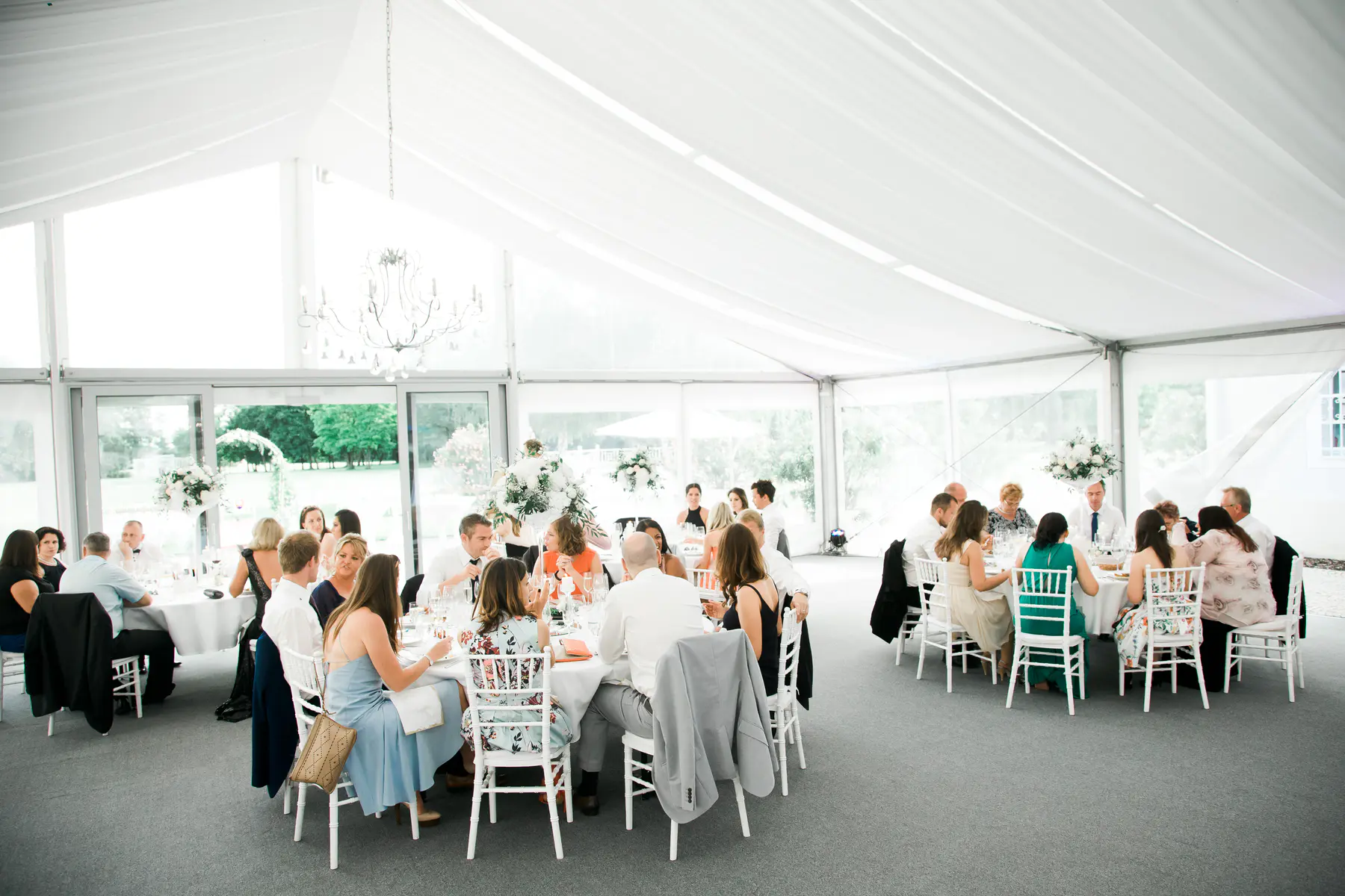 Wide-angle shot of a luxury white wedding tent setup in the park of Art Hotel Kastiel.