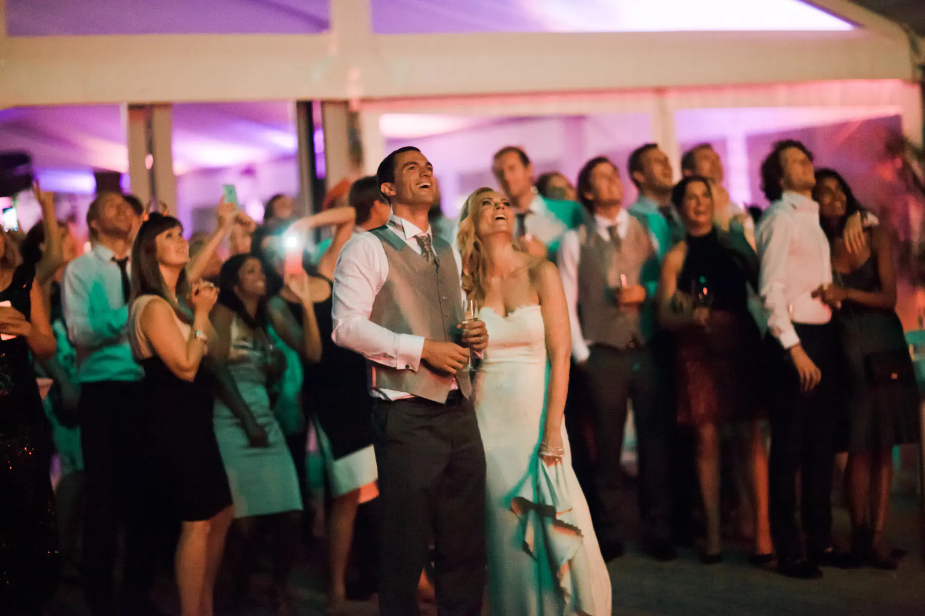 Newlyweds watching a professional fireworks show in the garden, luxury wedding photography.
