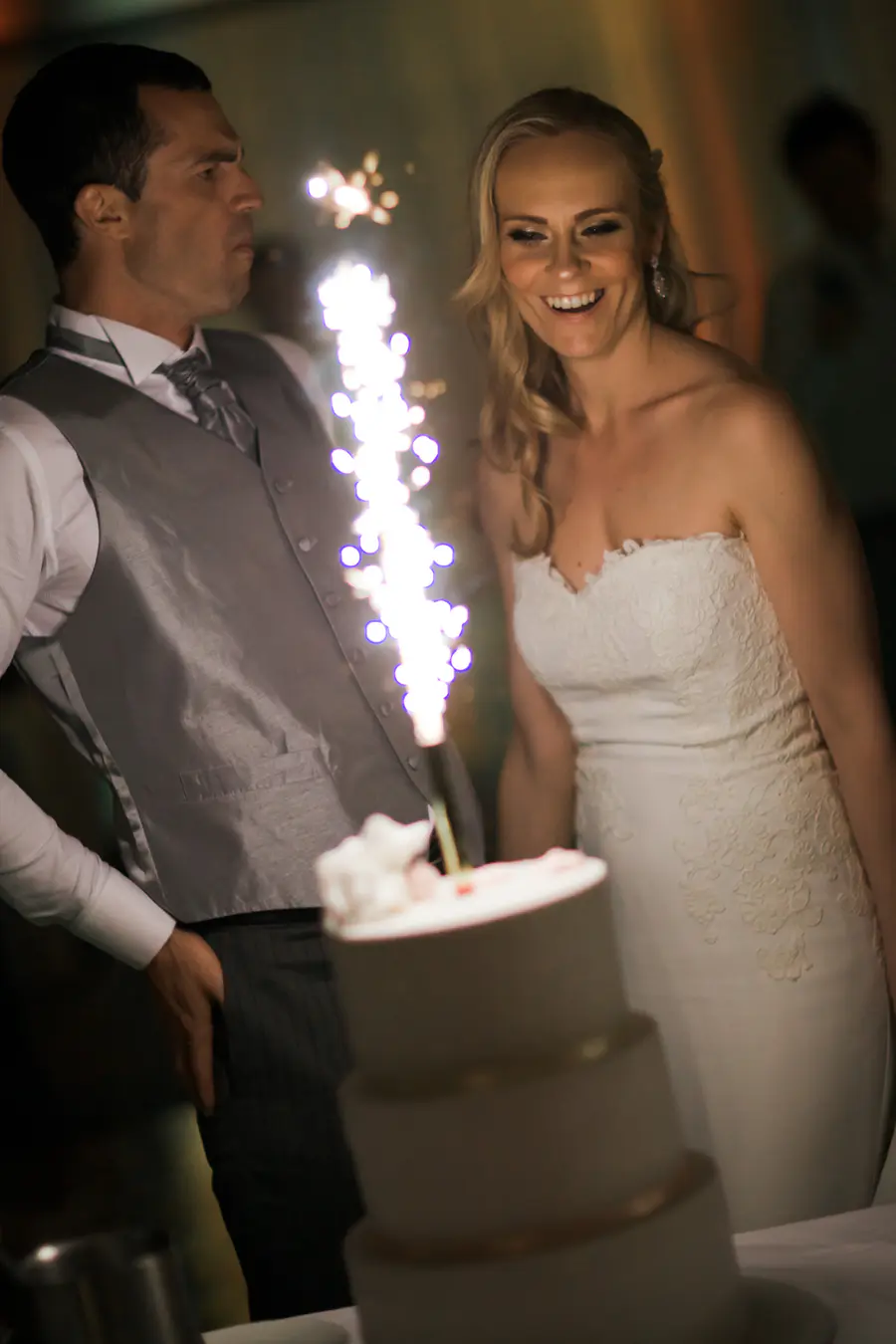 Bride and groom cutting their elegant wedding cake in the decorated white tent at Kastiel Tomasov.