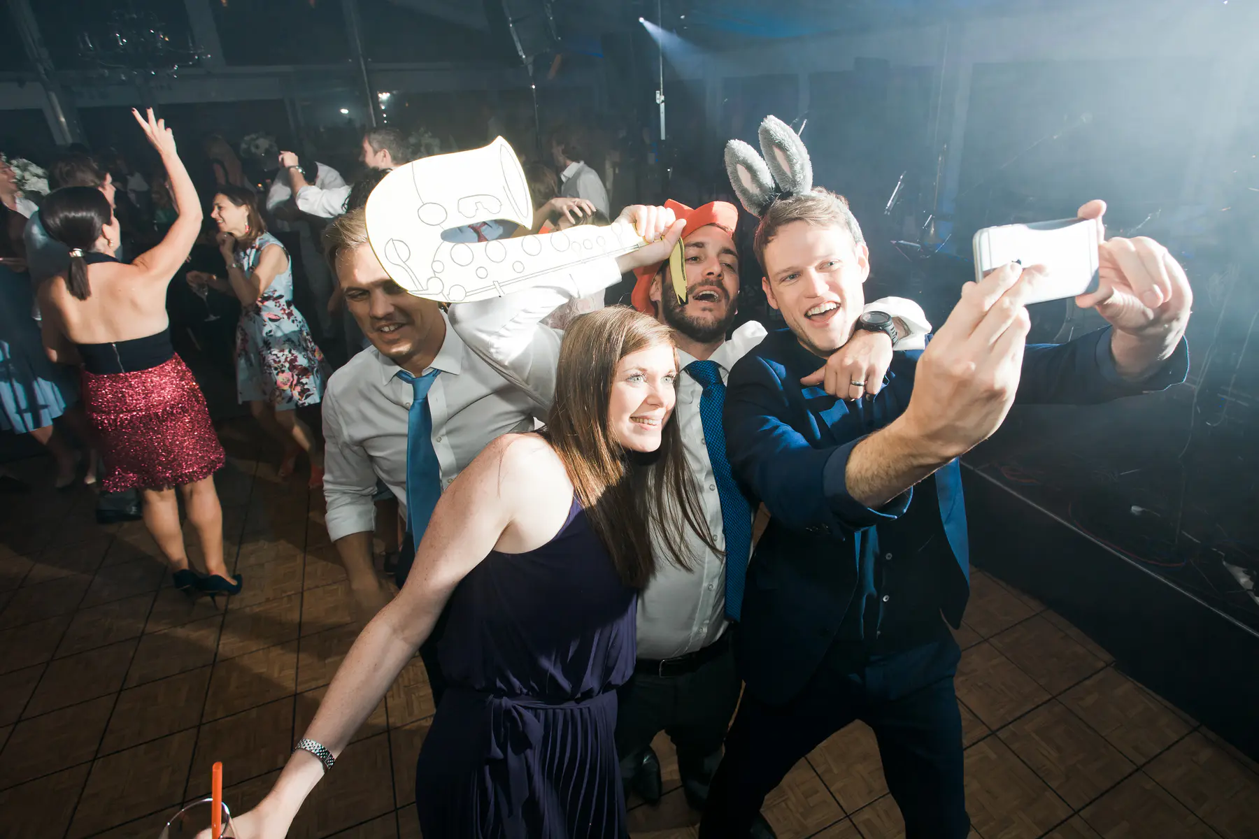 Candid shot of the wedding crowd having fun on the dance floor, captured by a professional photography duo.Strobist weeding photo