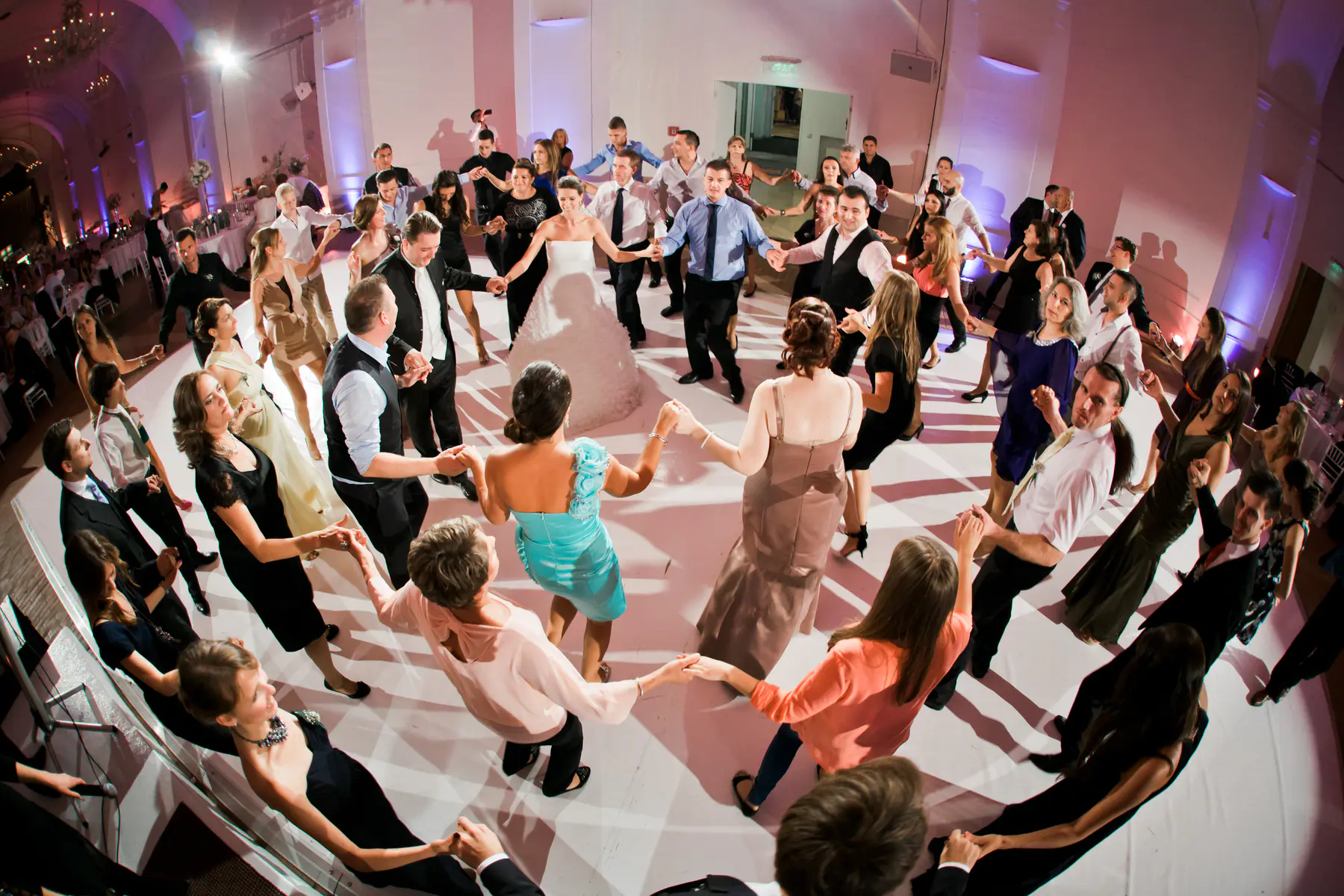 Everyone on the dance floor joining together for a celebratory circle dance, capturing the high energy and joy of the wedding party in Vienna.